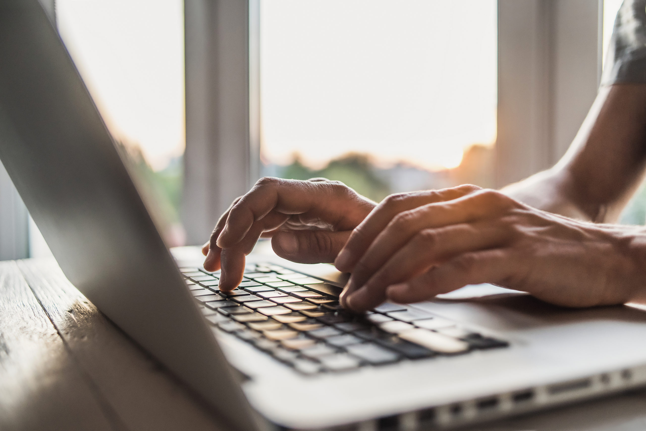 Men is typing on laptop computer keyboard