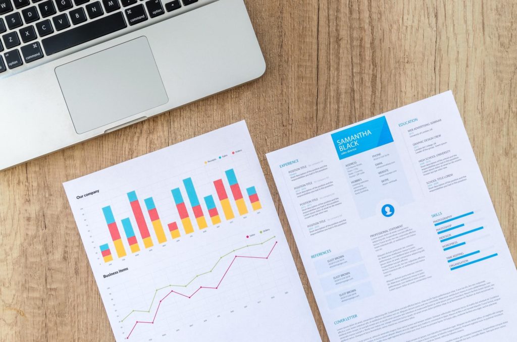 Resume and performance metrics next to laptop