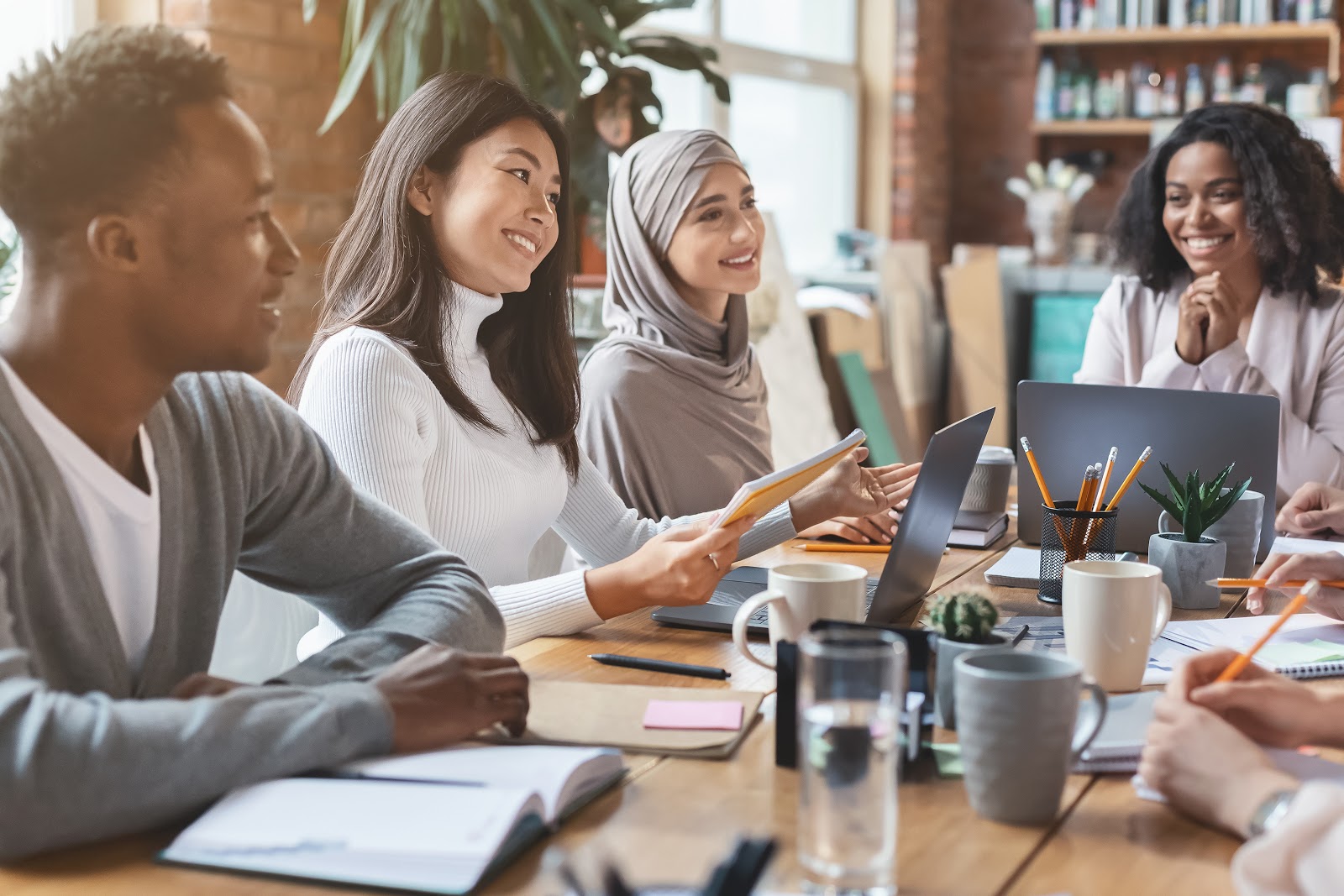 Group of mainly female coworkers sitting around a table during a meeting