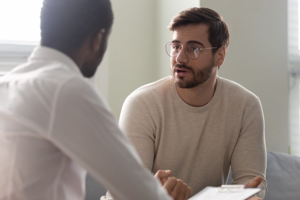 A young adult male sitting down with his EAP counselor