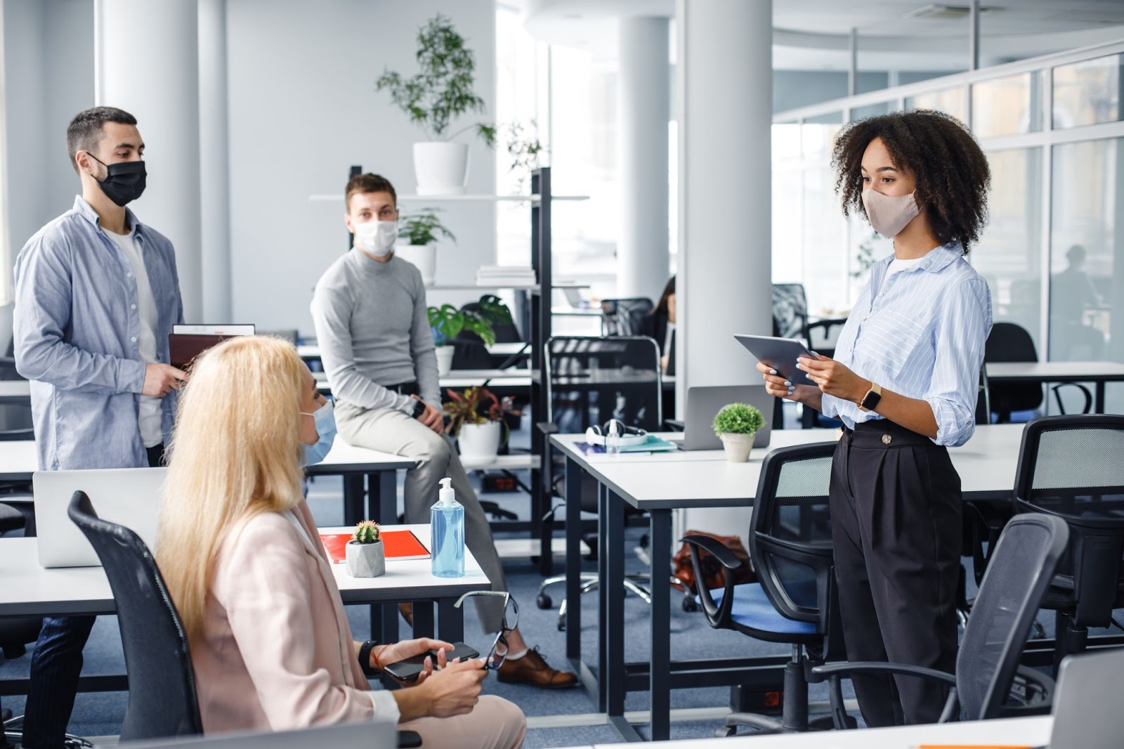 iStock-1281660191 Group of male and female coworkers holding a meeting in an open workspace