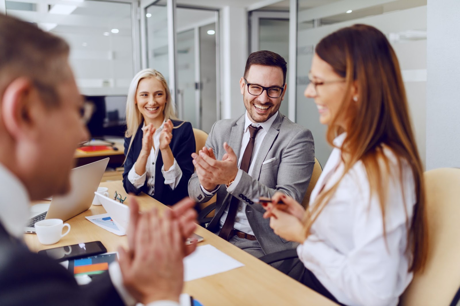 iStock-1199637569 Workers applauding one's accomplishment during a meeting