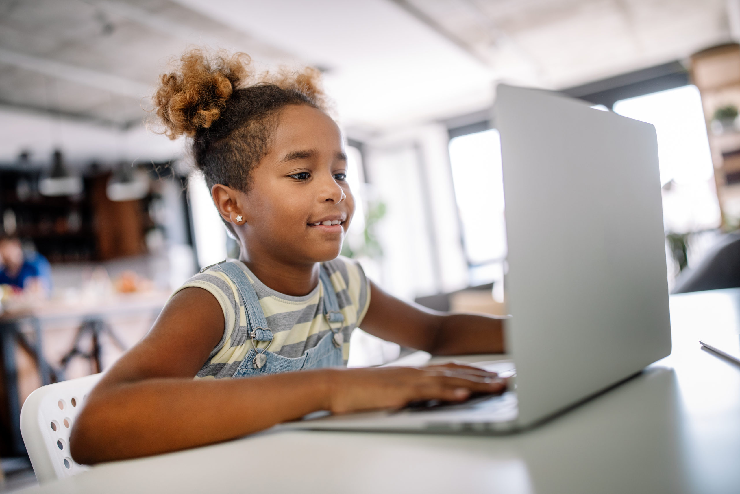 African kid girl spending time with notebook and modern technology