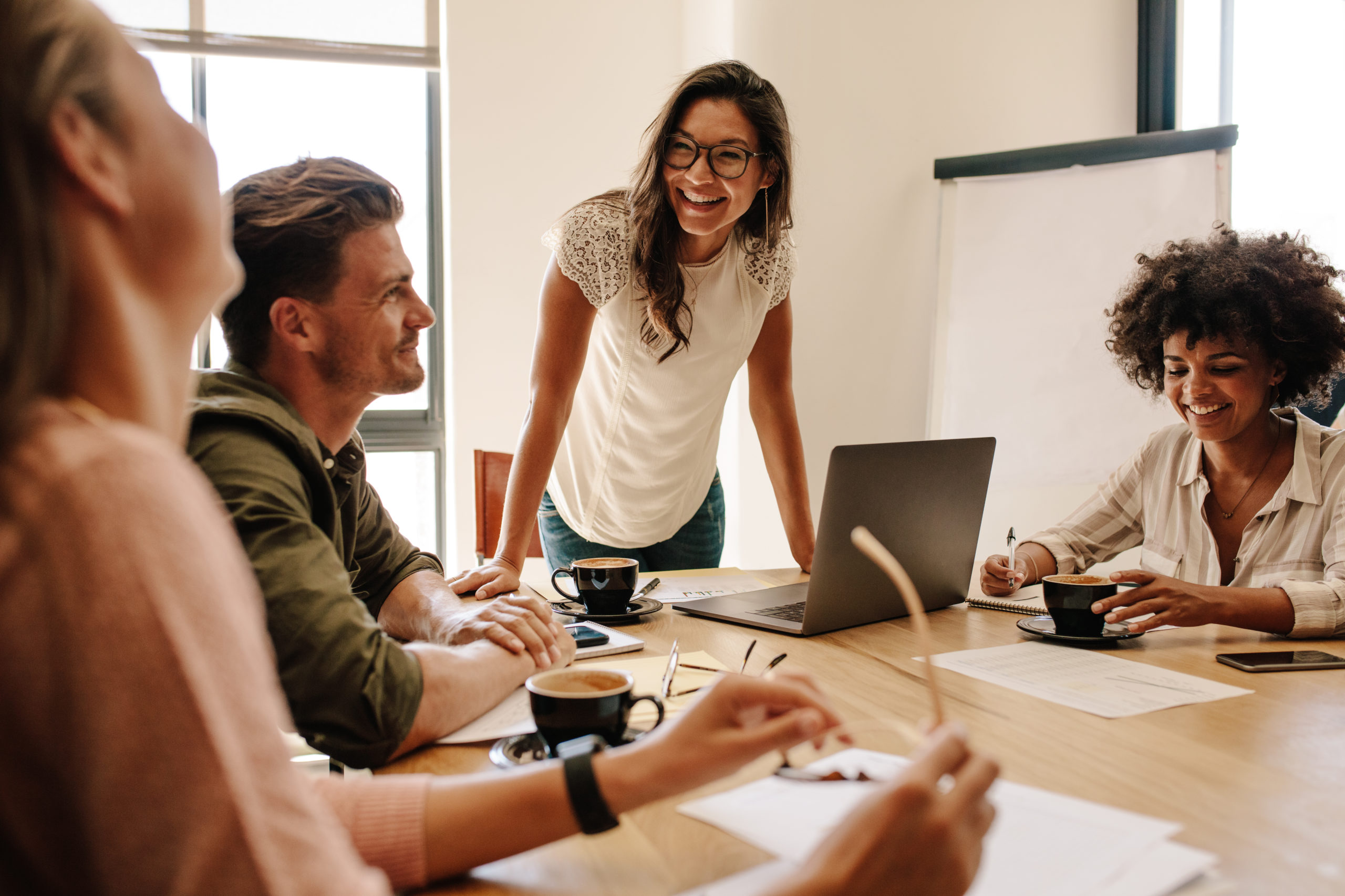 group-of-multi-ethnic-executives-discussing-during-a-meeting-business-man-and-woman-sitting-around-table-at-office-and-smiling-stockpack-istock Group of multi ethnic executives discussing during a meeting. Business man and woman sitting around table at office and smiling.