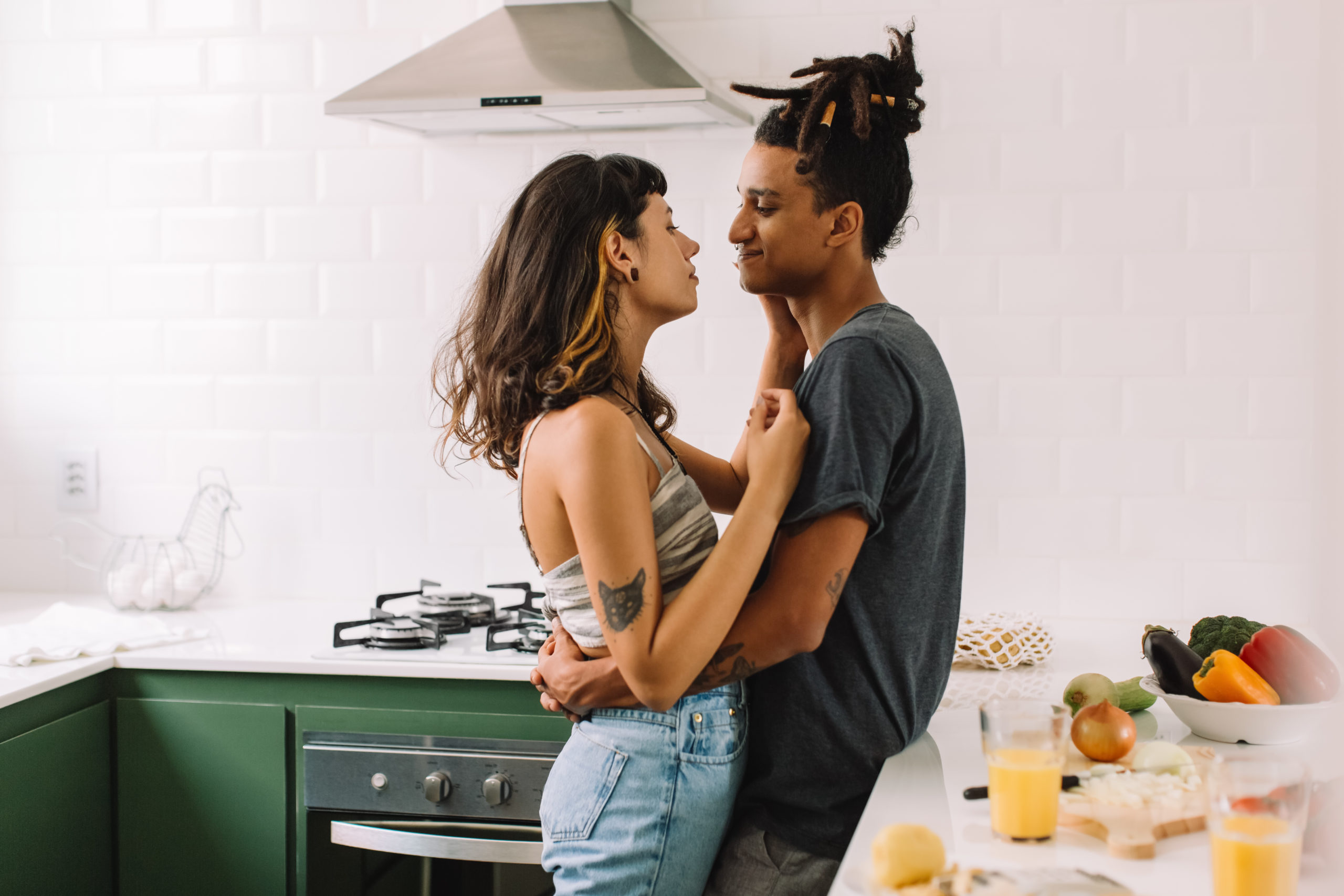 Beautiful young couple bonding in the kitchen. Cropped shot of an affectionate young couple embracing each other while standing together in their kitchen. Couple sharing a romantic moment at home.