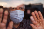 elderly-caucasian-man-wearing-hand-made-protective-face-mask-in-nursing-care-home-looking-outside-window-sadness-stress-hope-in-his-eyes-self-isolation-due-to-global-covid-19-coronavirus-pandemic-stockpack-istock Elderly caucasian man wearing hand made protective face mask, in nursing care home, looking outside window, sadness, stress & hope in his eyes, self isolation due to global COVID-19 Coronavirus pandemic