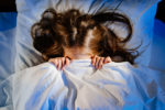 a-frightened-teenage-girl-covers-his-face-with-a-blanket-in-bed-in-her-room-sees-a-nightmare-restless-unhealthy-sleep-in-children-after-watching-a-horror-movie-childs-fear-stockpack-istock