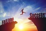 silhouette-of-business-man-jump-to-success-text-over-a-beautiful-high-view-mountain-background-stockpack-istock