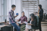 indian-white-collar-male-worker-in-wheelchair-having-cheerful-discussion-leading-conversation-with-colleague-in-creative-office-workstation-beside-window-stockpack-gettyimages