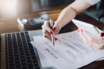 woman-holding-pen-over-resume-application-with-smart-phone-and-using-computer-laptop-to-job-search-on-online-internet-applying-for-a-job-concept-stockpack-gettyimages