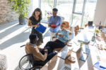 working-process-mature-businesswoman-talking-about-something-with-her-young-colleagues-while-sitting-together-at-the-office-table-in-the-modern-office-stockpack-gettyimages