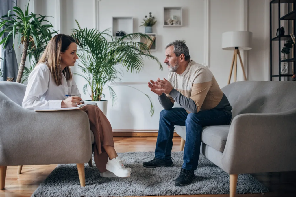 Psychotherapy, young woman doctor talking to an older man