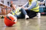 selective-focus-at-hat-men-worker-feel-painful-and-hurt-from-the-accident-that-happen-inside-of-industrial-factory-while-his-co-worker-come-to-give-emergency-assistance-and-help-accident-in-factory-stockpack-gettyimages Selective focus at hat, Men worker feel painful and hurt from the accident that happen inside of industrial factory while his co-worker come to give emergency assistance and help. Accident in factory.